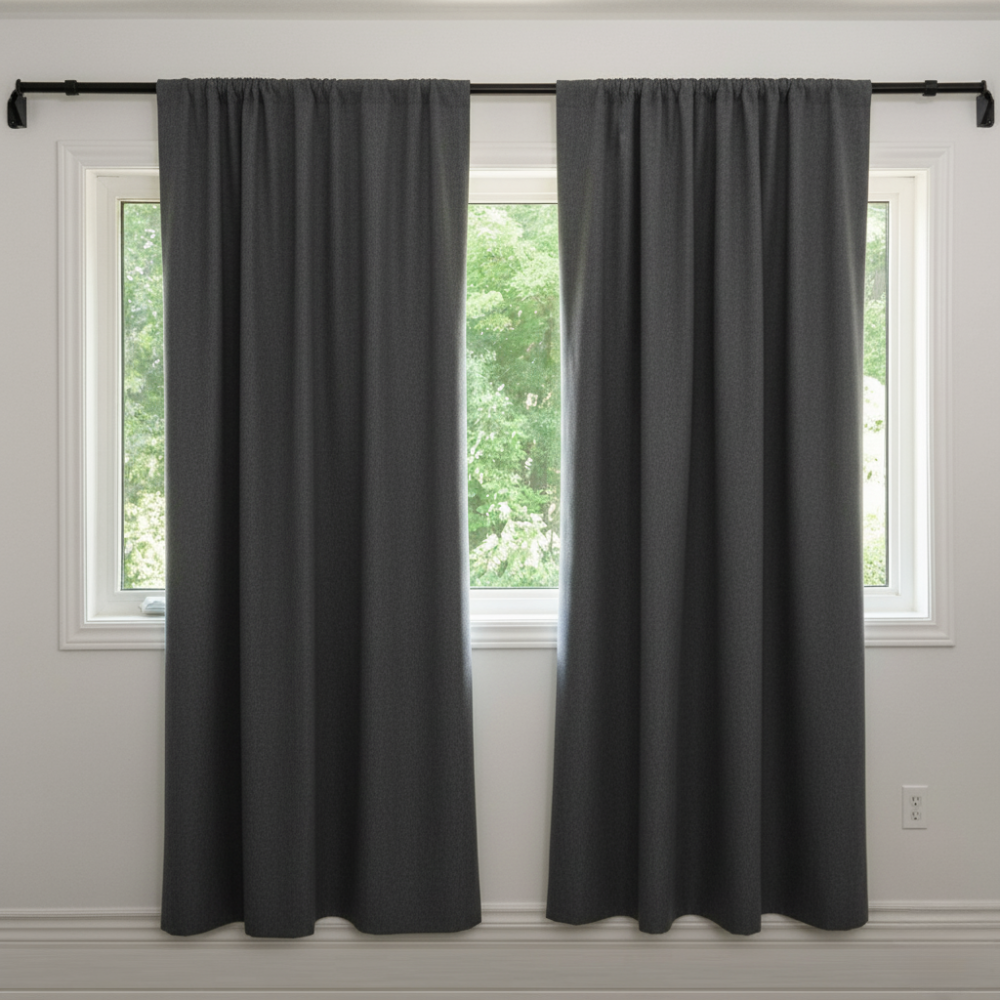 Beige curtain hanging in a room beside a potted palm plant.