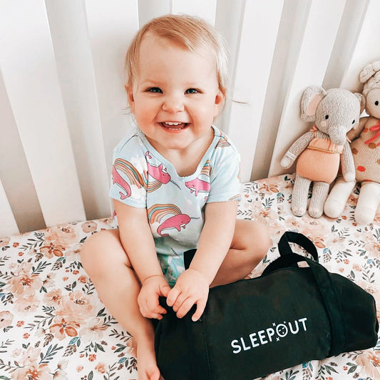 Baby in a crib with a Sleepout Portable