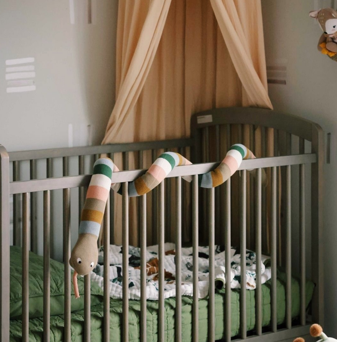 bright baby nursery, crib lined with mattress and sheets